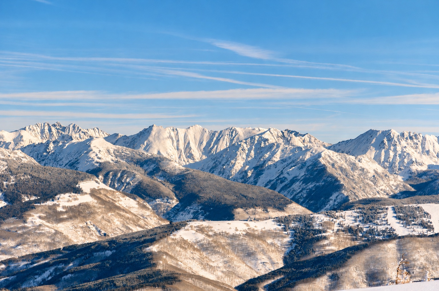 Snow-covered mountains in warm golden winter sunlight